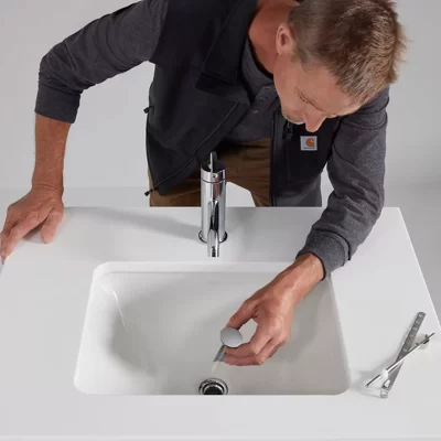 Image of a man installing a plumbing fixture